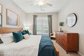 Charlotte apartment for rent - A bedroom with a large bed and a ceiling fan.