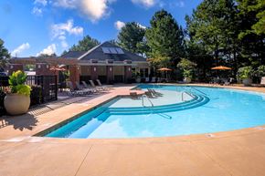 Raleigh apartment for rent - A swimming pool with a sun lounger and a building in the background.
