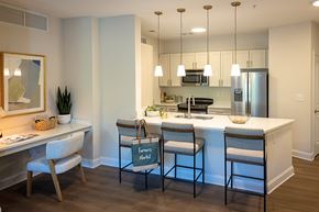 Raleigh apartment for rent - A kitchen with a white counter top and bar stools.