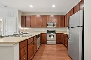 Charlotte apartment for rent - A kitchen with brown cabinets and a white fridge.