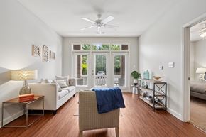 Charlotte apartment for rent - A living room with a sofa, a chair, and a table with a lamp on it.