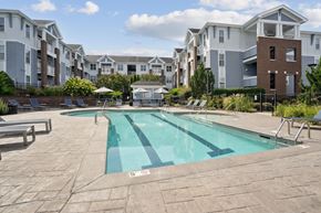 Charlotte apartment for rent - A swimming pool in a residential area with apartment buildings in the background.