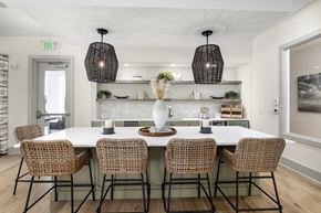 Surf City apartment for rent - a dining room with a large white table and rattan chairs