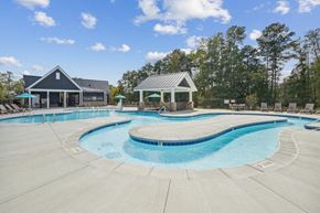 Raleigh townhouse for rent - a resort style pool with chairs around it and a house in the background