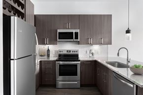 Allen apartment for rent - a kitchen with stainless steel appliances and wooden cabinets