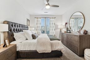 Charlotte apartment for rent - A bedroom with a large bed, a headboard, and a ceiling fan.