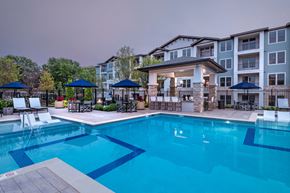 New Market apartment for rent - a swimming pool with chairs and umbrellas in front of an apartment building