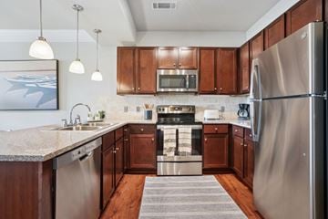 Mooresville apartment for rent - A modern kitchen with wooden cabinets and stainless steel appliances.