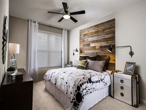 Frederick apartment for rent - A bedroom with a bed, dresser, and a wooden headboard.