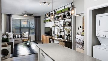 Frederick apartment for rent - A modern kitchen with a large island and a living area with a sofa and a coffee table.