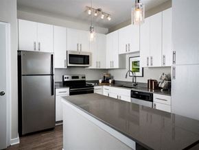 Frederick apartment for rent - A modern kitchen with a stainless steel refrigerator and a microwave above the stove.