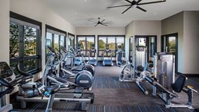 Frederick apartment for rent - A gym with a variety of equipment including treadmills, weights, and a ceiling fan.