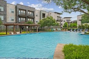 Farmers Branch apartment for rent - A large swimming pool in front of apartment buildings.
