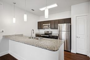 Garland apartment for rent - a kitchen with granite counter tops and a stainless steel refrigerator