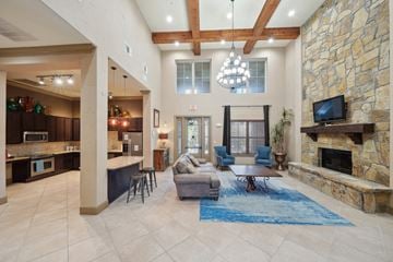 Denton apartment for rent - the living room has a large stone fireplace and a blue rug
