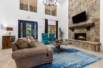 Denton apartment for rent - A living room with a brown couch and a stone fireplace.