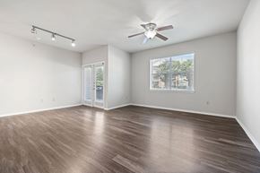 Denton apartment for rent - A room with a ceiling fan and a window with a view of a fence and trees.