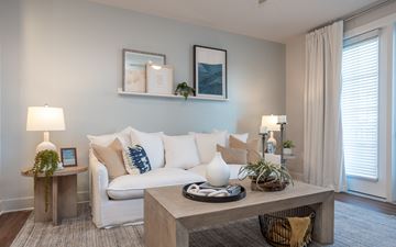 Carolina Beach apartment for rent - A living room with a white couch, a wooden table, and a painting on the wall.