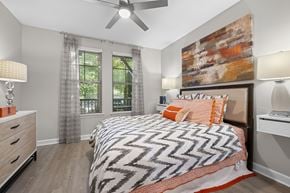 Johns Creek apartment for rent - A bedroom with a large bed and a ceiling fan.