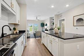 Greensboro apartment for rent - A modern kitchen with white cabinets and black countertops.