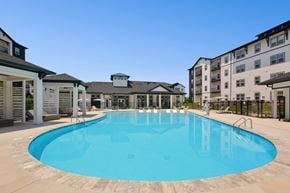 Greensboro apartment for rent - A large outdoor swimming pool surrounded by apartment buildings.