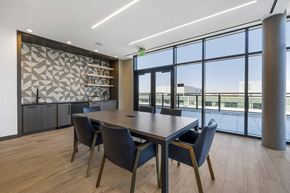 Washington apartment for rent - a meeting room with large windows and a wooden table with blue chairs