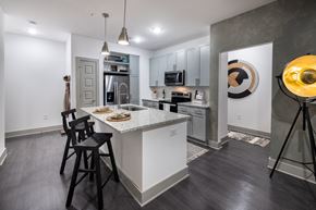 Duluth apartment for rent - A modern kitchen with a white island and black chairs.
