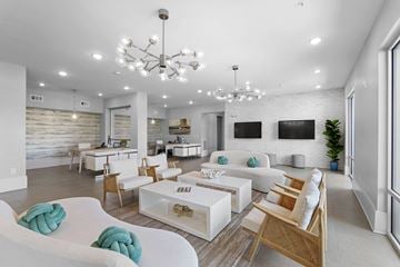 Jacksonville apartment for rent - A modern living room with white furniture and a chandelier.