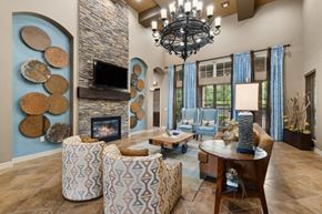 Rockwall apartment for rent - A living room with a stone fireplace and a chandelier.