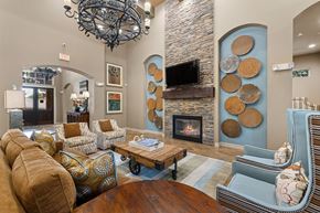 Rockwall apartment for rent - A living room with a stone fireplace and a chandelier.