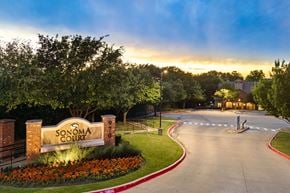 Rockwall apartment for rent - The image shows the entrance to Sonoma Court with a beautifully landscaped garden and a clear sky.