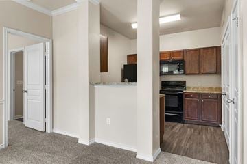 Rockwall apartment for rent - A kitchen with white cabinets and a black fridge.