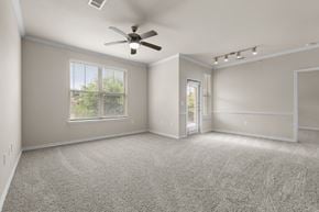 Rockwall apartment for rent - A spacious room with a ceiling fan and carpeted floor.