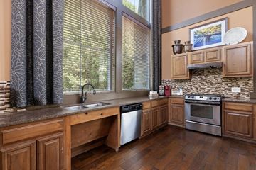 Denton apartment for rent - A kitchen with wooden cabinets and a stone backsplash.
