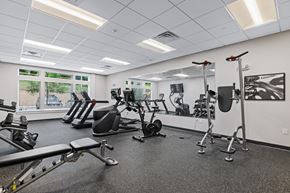 Raleigh apartment for rent - A gym with a variety of equipment including treadmills, weights, and exercise machines.