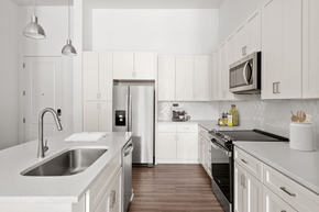 Wilmington apartment for rent - A modern kitchen with white cabinets and stainless steel appliances.