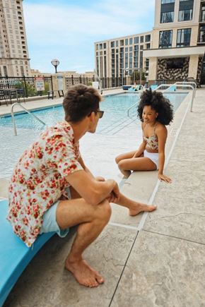 Atlanta apartment for rent - Stock photo of a two people sitting on the edge of the pool