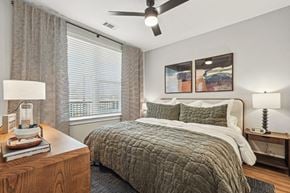 Charlotte apartment for rent - A bedroom with a large bed and a ceiling fan.