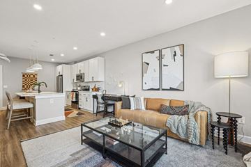 Charlotte apartment for rent - A modern living room with a glass coffee table and a couch.