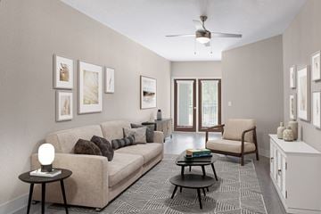 Jacksonville apartment for rent - a living room with a couch and a chair and a ceiling fan