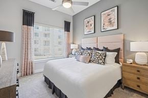 Durham apartment for rent - A bedroom with a large bed, a nightstand, and a ceiling fan.