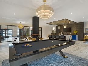 Woodbridge apartment for rent - A pool table is in the middle of a room with a blue carpet.