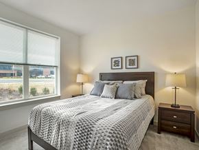Woodbridge apartment for rent - A bedroom with a large bed and two lamps.
