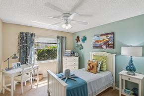Rockledge apartment for rent - A bedroom with a bed, desk, chair, and window.