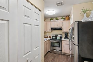 Rockledge apartment for rent - A kitchen with a black refrigerator, white cabinets, and a black stove top oven.