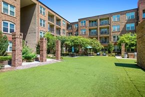 Frisco apartment for rent - A grassy courtyard is surrounded by apartment buildings.
