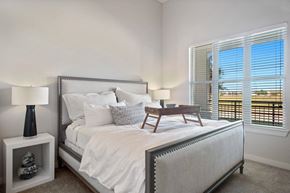Frisco apartment for rent - A bedroom with a large bed and a window with blinds.