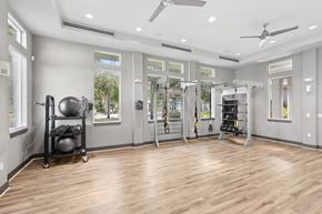 Clearwater apartment for rent - A spacious home gym with wooden floors and various exercise equipment.