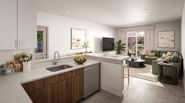 Roseland triplex for rent - A modern kitchen with a wooden island and a green sofa in the living room.
