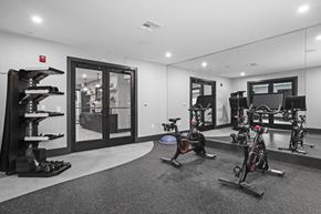 Florham Park apartment for rent - A gym with a row of stationary bikes and a row of dumbbells.